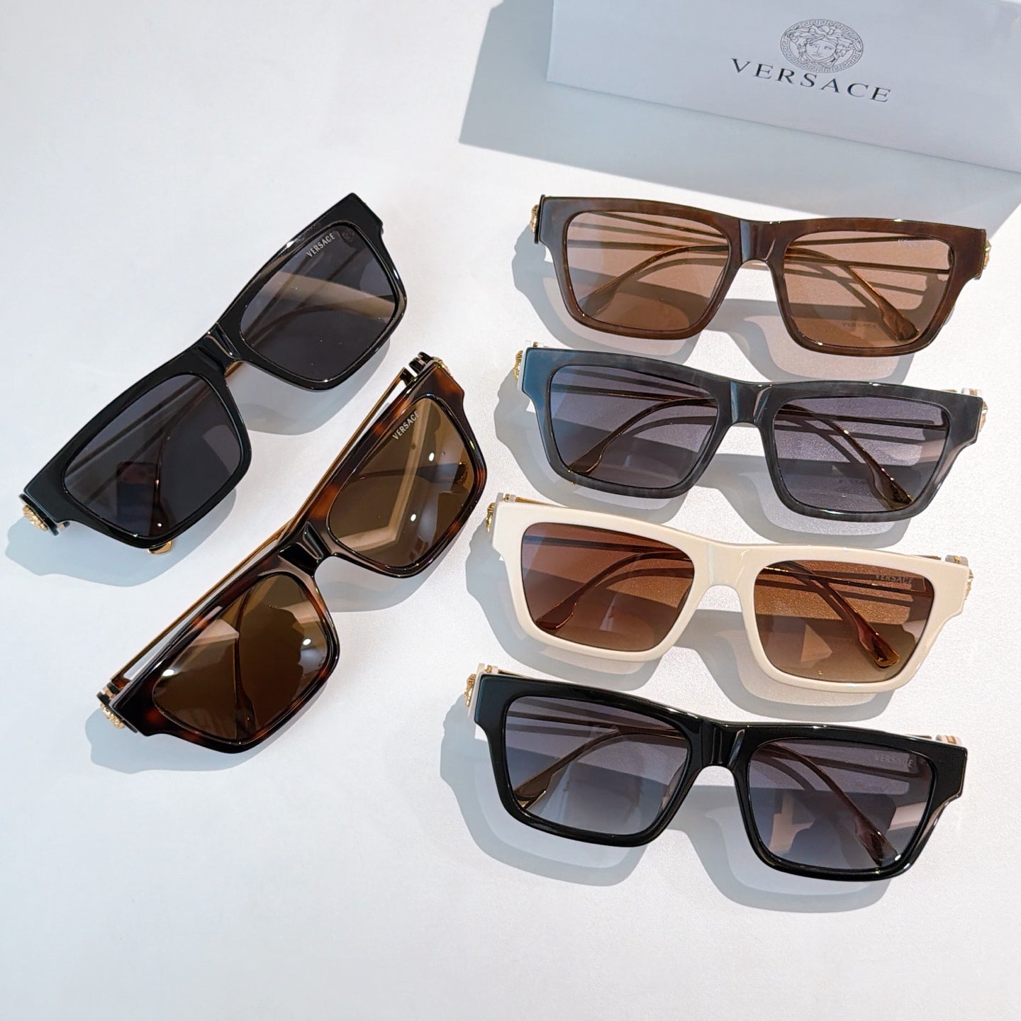 Assorted square sunglasses with dark, brown, and white frames and tinted lenses