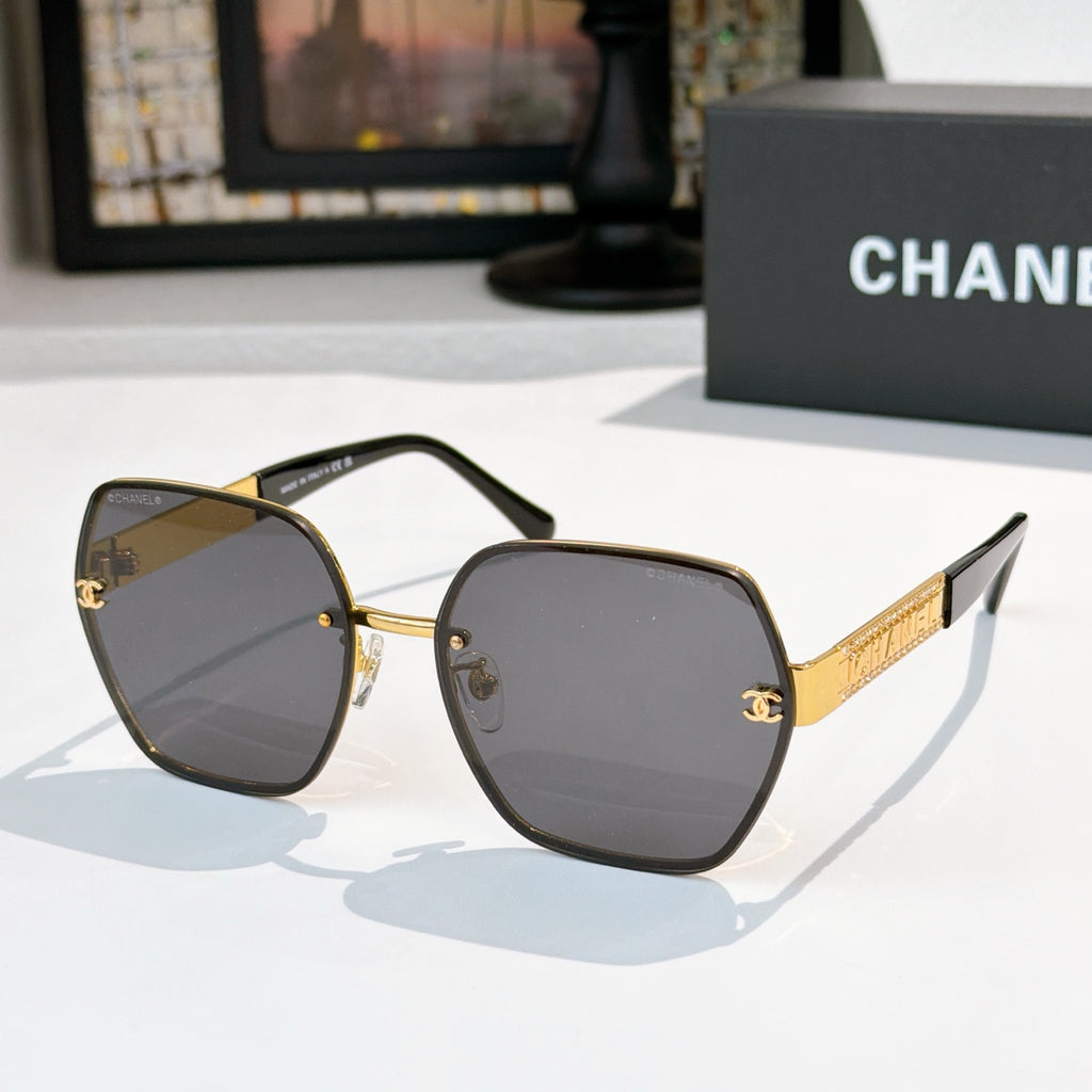 Sunglasses with dark gray lenses, gold-tone square frames, black temples and gold logo bar.