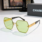 Sunglasses with light green lenses, gold-tone square frames, black temples with gold logo bar.