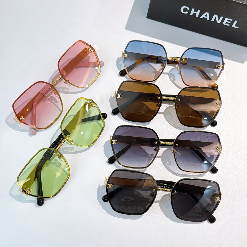 Assorted sunglasses with square frames and tinted lenses, including pink, green, blue, and black.