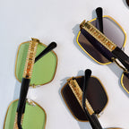 Sunglasses close-up set: green and black tinted square lenses with gold studded temple bars.