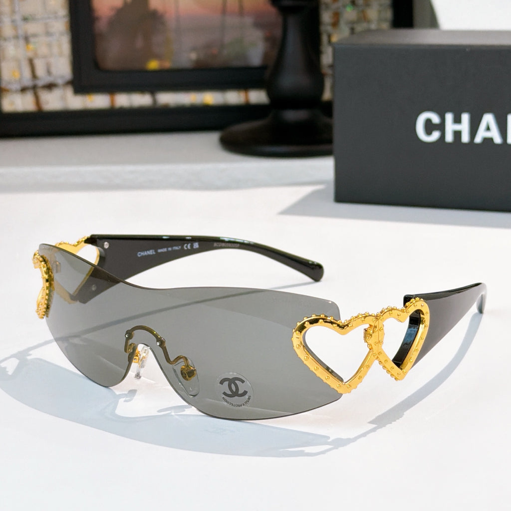 Gold heart-accent sunglasses with dark frames and gray tinted lenses