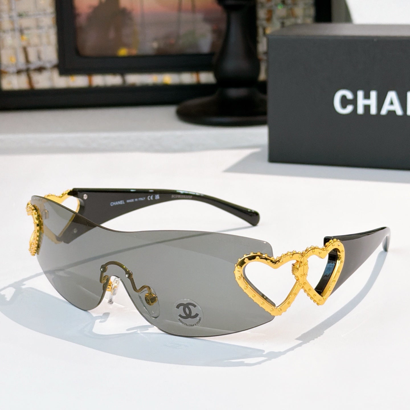 Gold heart-accent sunglasses with dark frames and gray tinted lenses