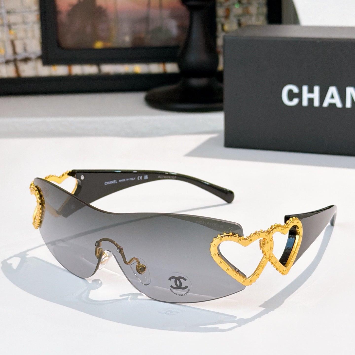 Gold heart-accent sunglasses with dark frames and gray tinted lenses