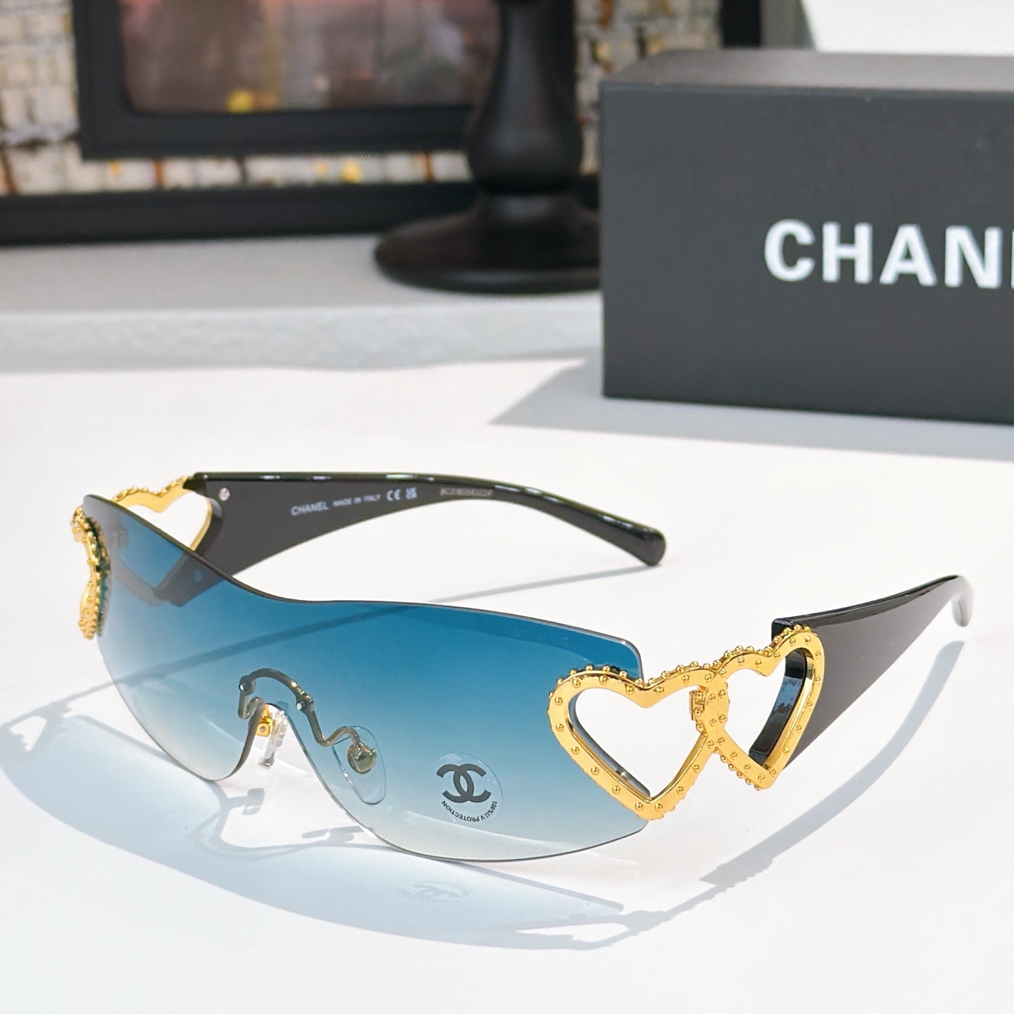 Gold heart-accent sunglasses with blue tinted lenses and dark frames