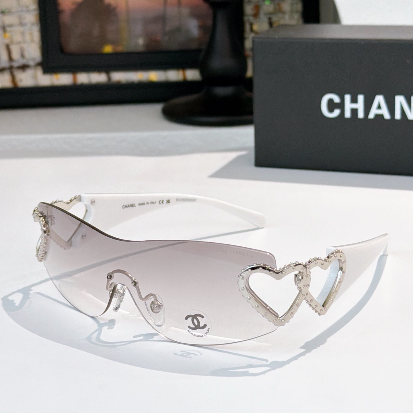 Silver heart-accent sunglasses with white frames and clear lenses