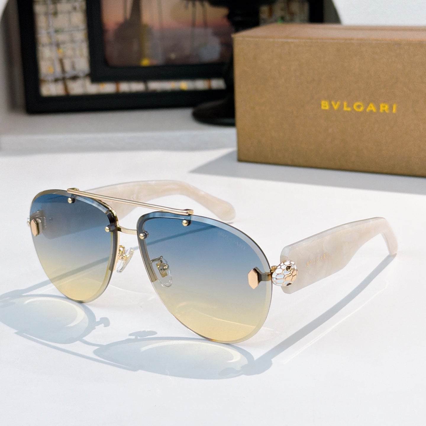 Bvlgari sunglasses with silver frame, blue gradient lenses, pale temples with gold hardware