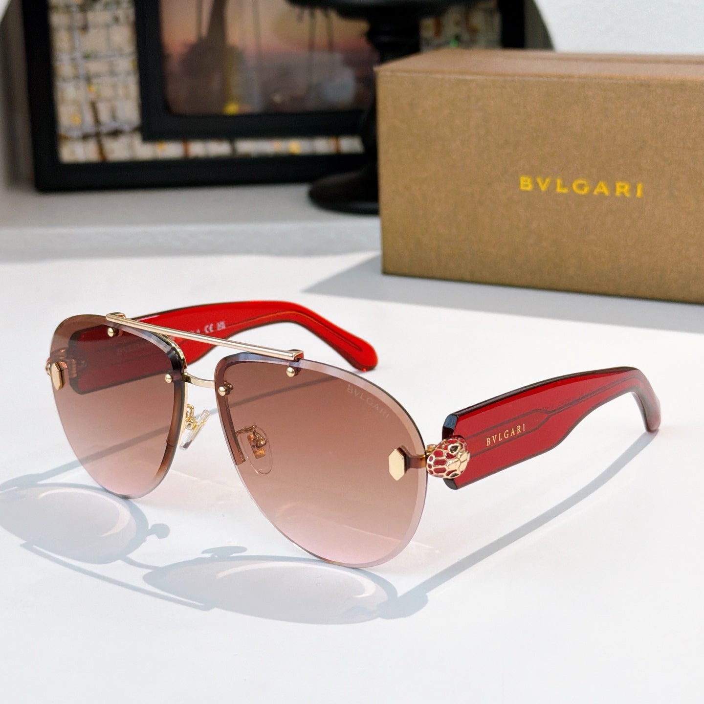 Bvlgari sunglasses with gold frame, rose-tinted lenses, red temples and gold hardware