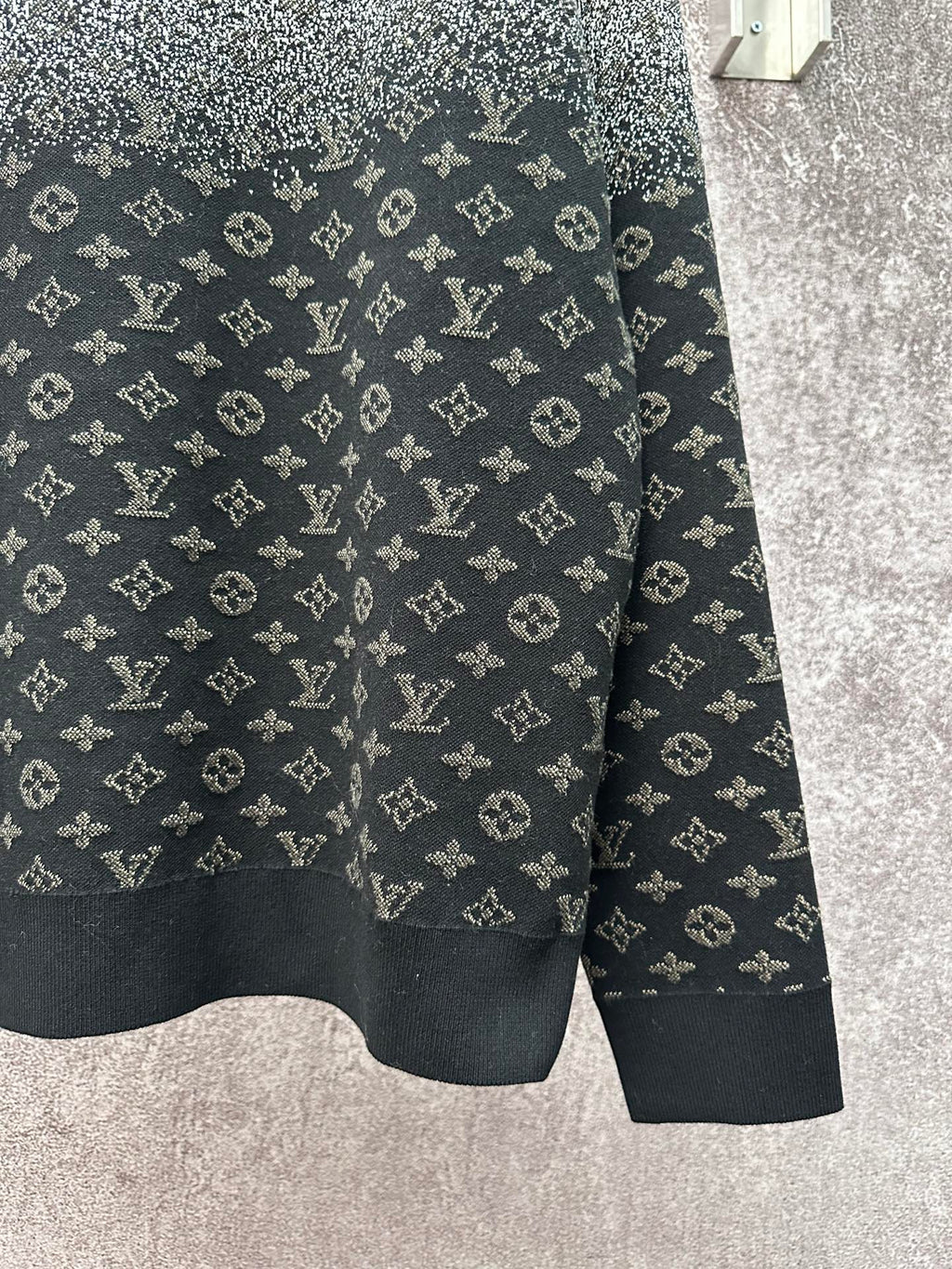 Knit sweater hem with LV monogram pattern, dark navy base and light gray speckle