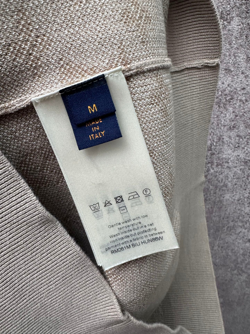 Interior neck label on light beige long-sleeve sweatshirt, size M in navy tag