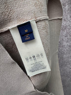 Interior neck label on light beige long-sleeve sweatshirt, size M in navy tag