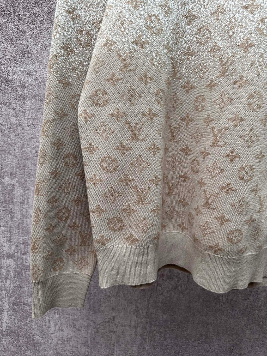 Side view light beige long-sleeve sweatshirt with monogram pattern and ribbed hem