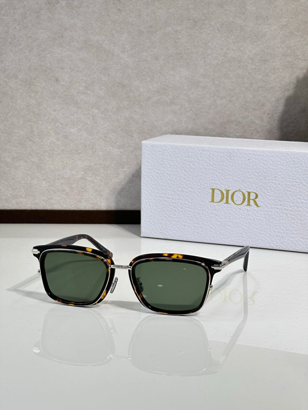 Black sunglasses with green-tinted lenses and gold-tone accents