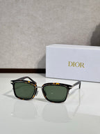 Black sunglasses with green-tinted lenses and gold-tone accents
