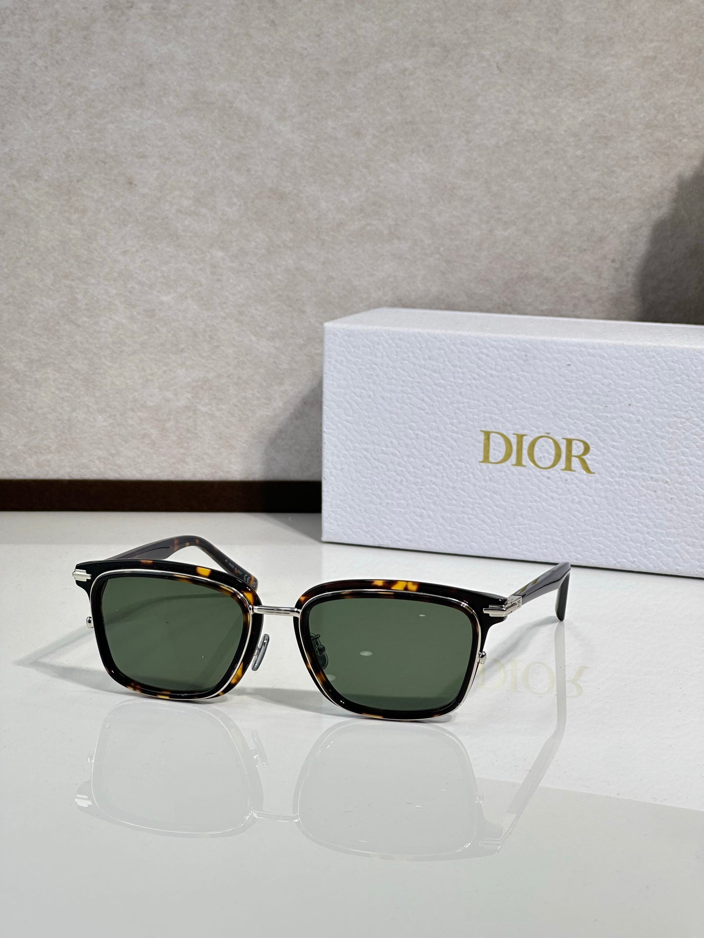Black sunglasses with green-tinted lenses and gold-tone accents