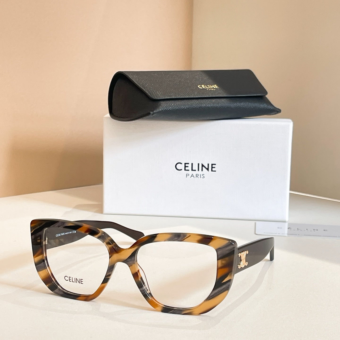 Celine glasses with tortoiseshell square frames and clear lenses, gold temple detail.