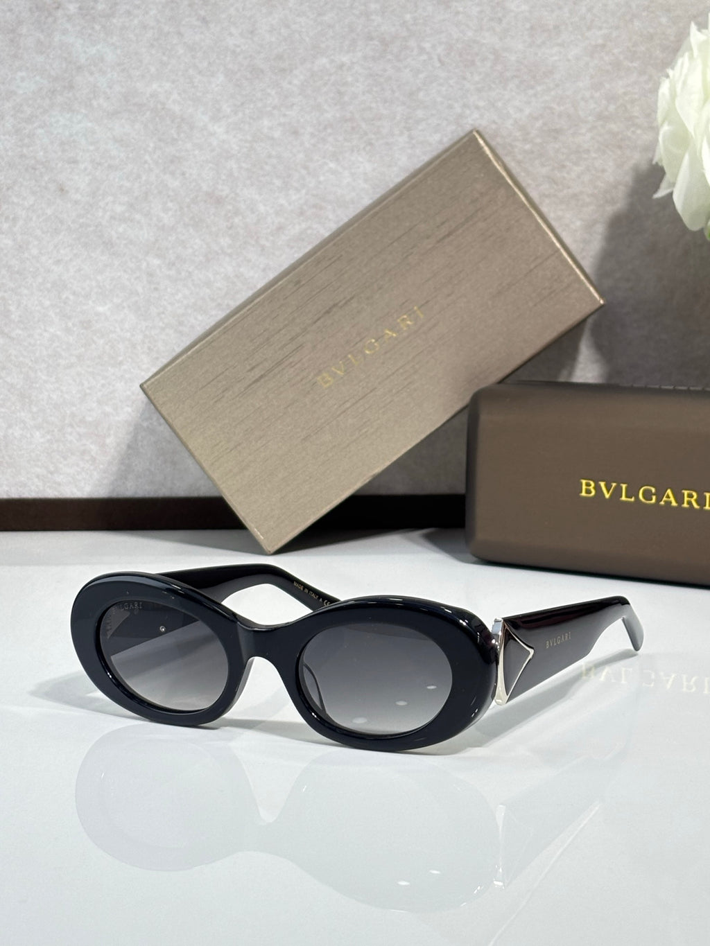 Bvlgari sunglasses, black oval frame with dark lenses and gold logo detail