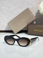 Bvlgari sunglasses with black frames and dark lenses, gold-trim temple detail