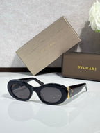 Bvlgari sunglasses with black frames and round dark lenses, gold temple detail
