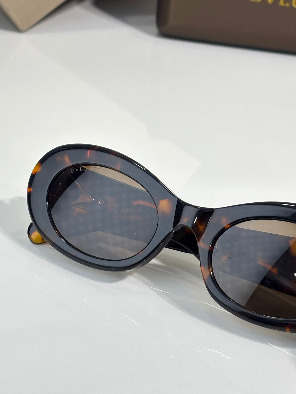 Bvlgari sunglasses close-up, tortoiseshell frame with dark lenses and gold details