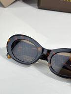 Bvlgari sunglasses close-up, tortoiseshell frame with dark lenses and gold details