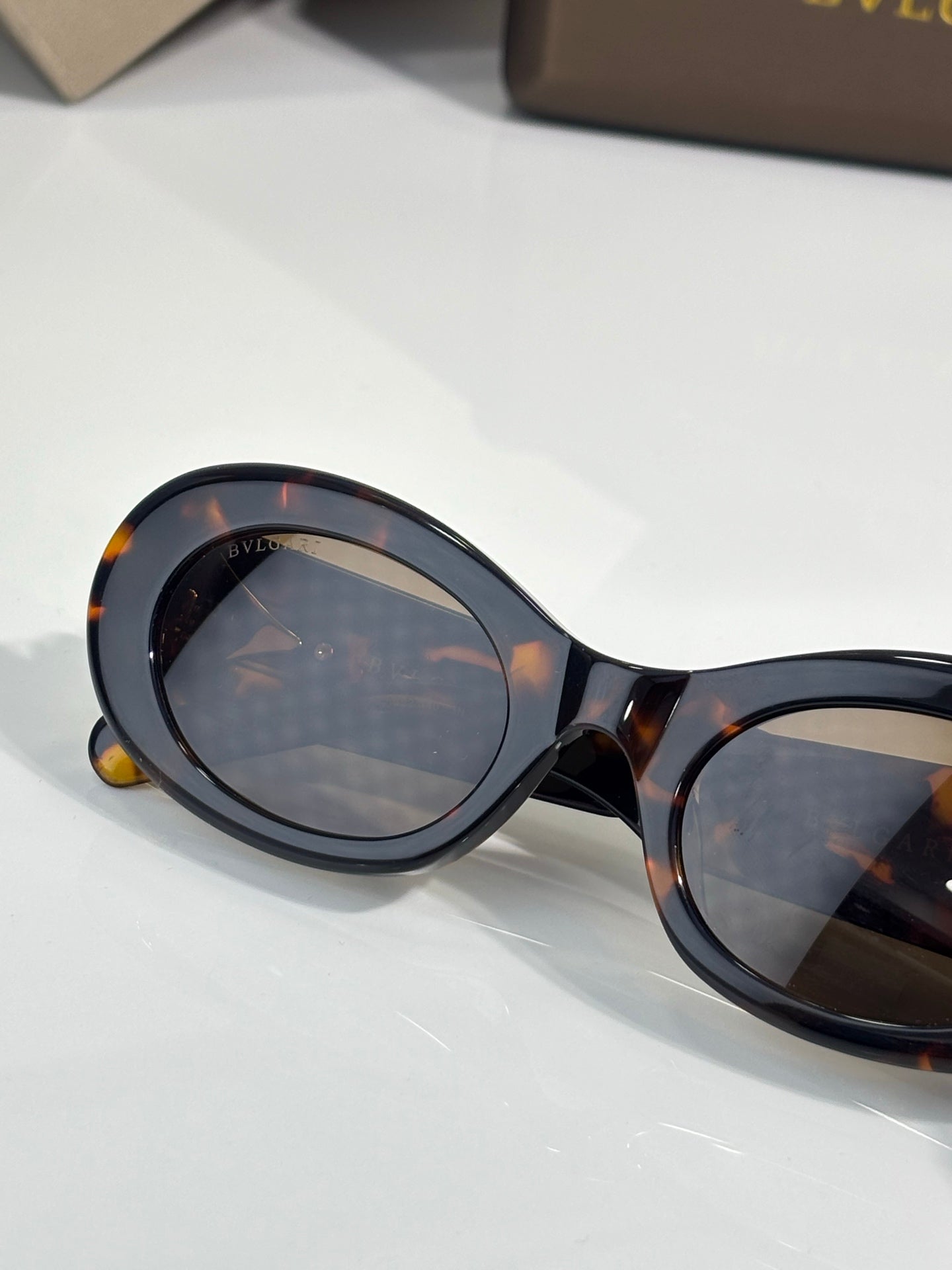 Bvlgari sunglasses close-up, tortoiseshell frame with dark lenses and gold details