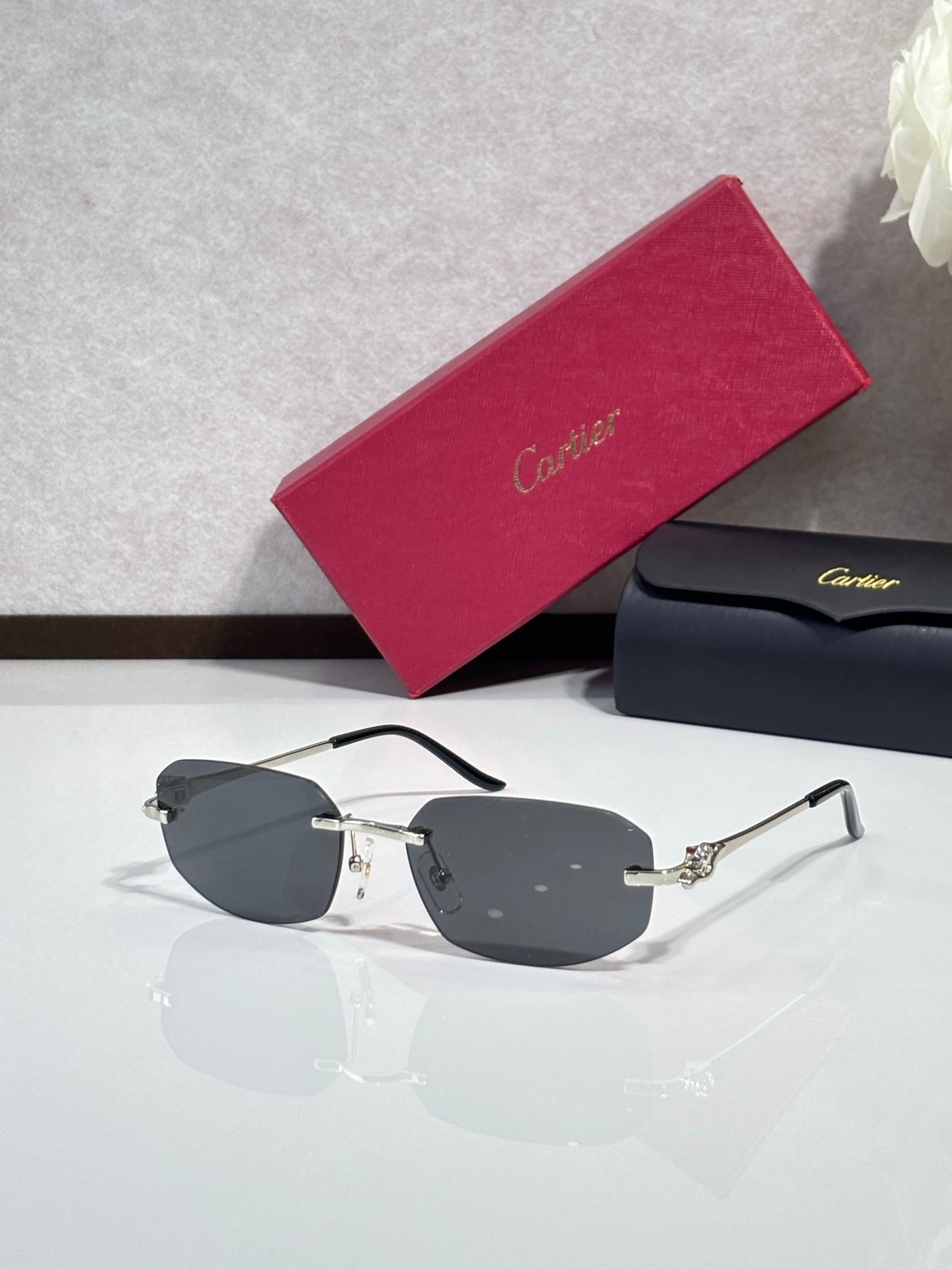 Gold-tone sunglasses with dark gray lenses and sculpted metal temple details