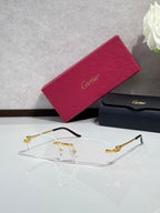 Gold-tone eyeglasses with clear lenses and sculpted metal temple details