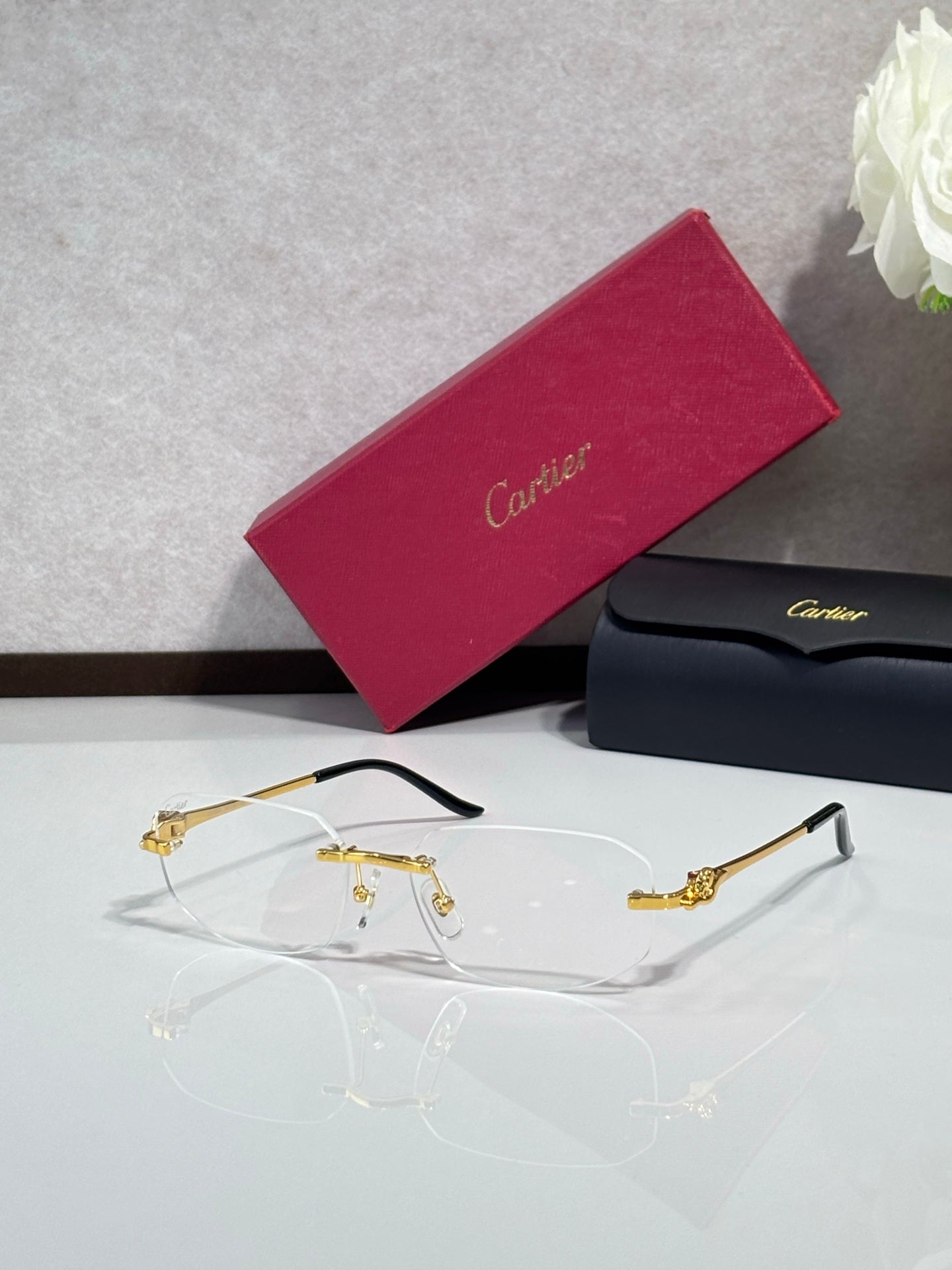 Gold-tone eyeglasses with clear lenses and sculpted metal temple details