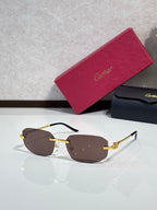 Gold-tone sunglasses with brown lenses and ornate metal temple details