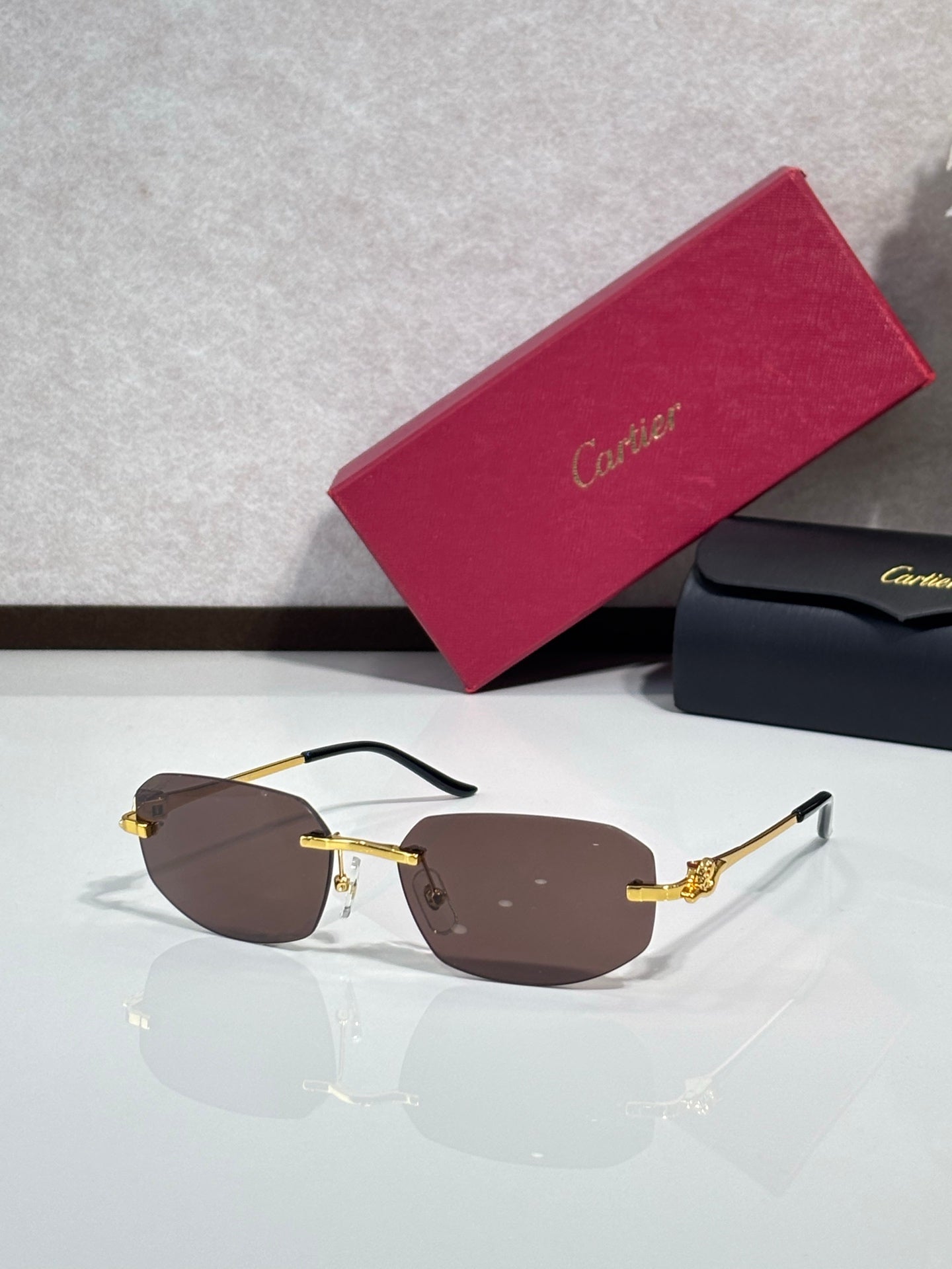 Gold-tone sunglasses with brown lenses and ornate metal temple details