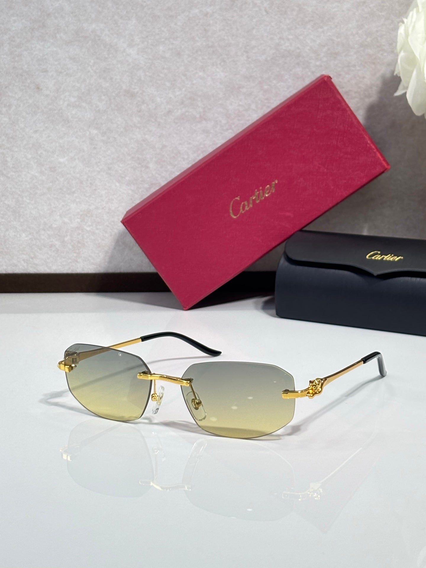 Gold-tone sunglasses with light gray lenses and black-and-gold temple arms