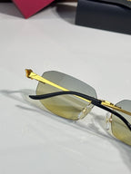 Cartier sunglasses angled view: gold frame, light amber lenses, dark temples