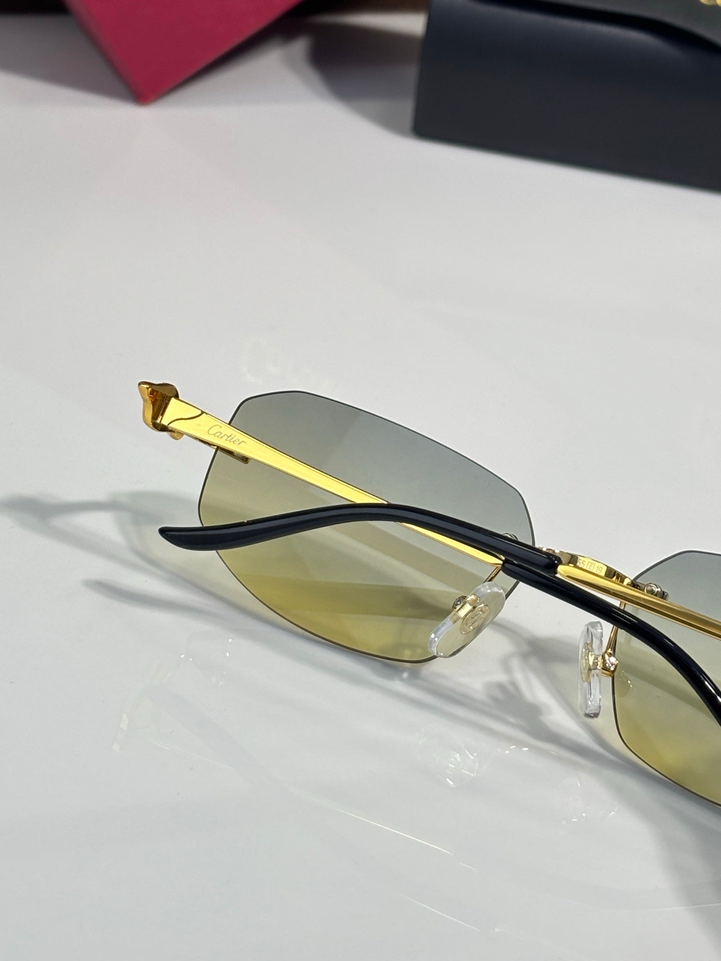 Cartier sunglasses angled view: gold frame, light amber lenses, dark temples