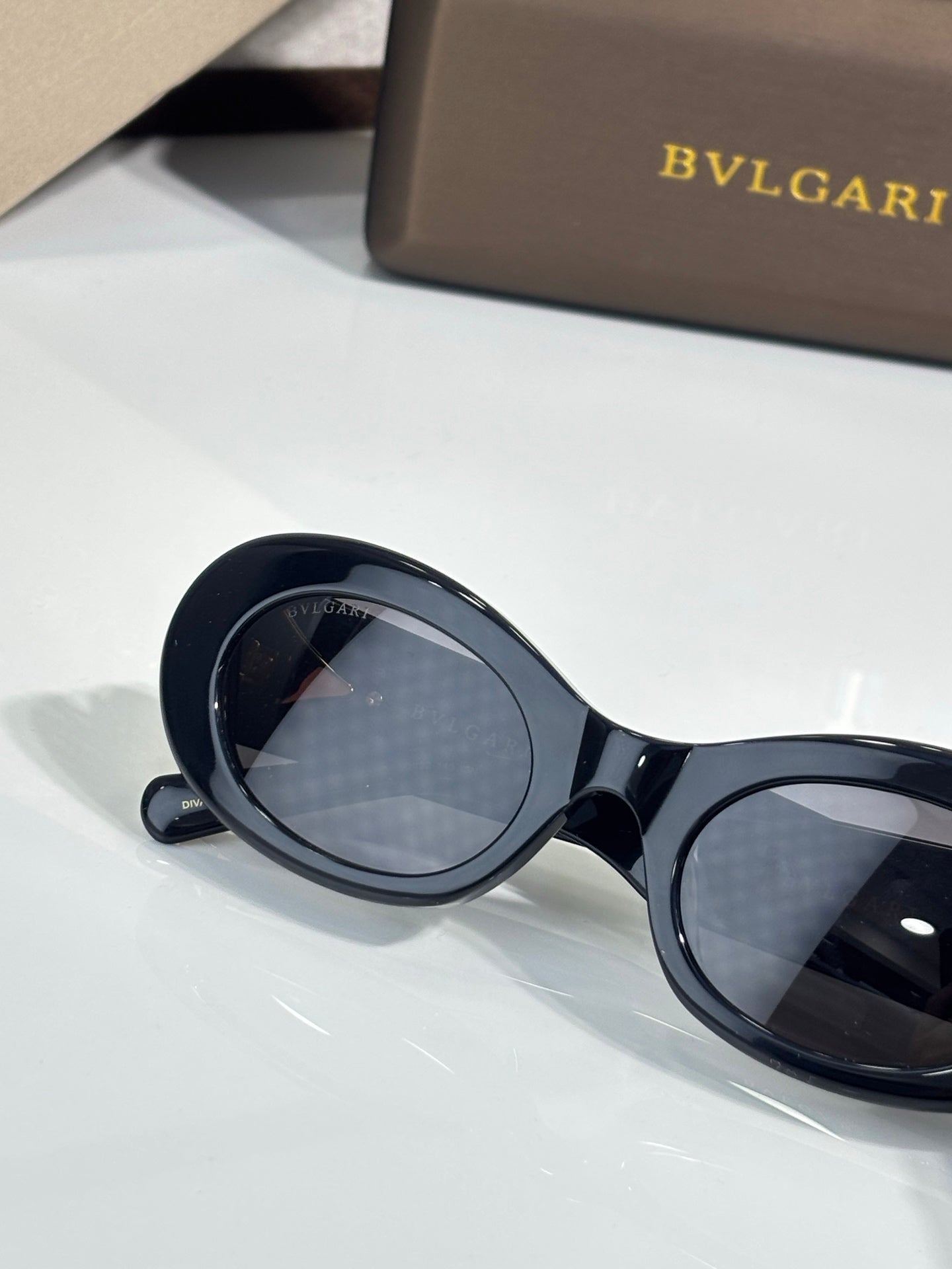 BVLGARI sunglasses close-up with dark tinted lenses and black round-oval frame
