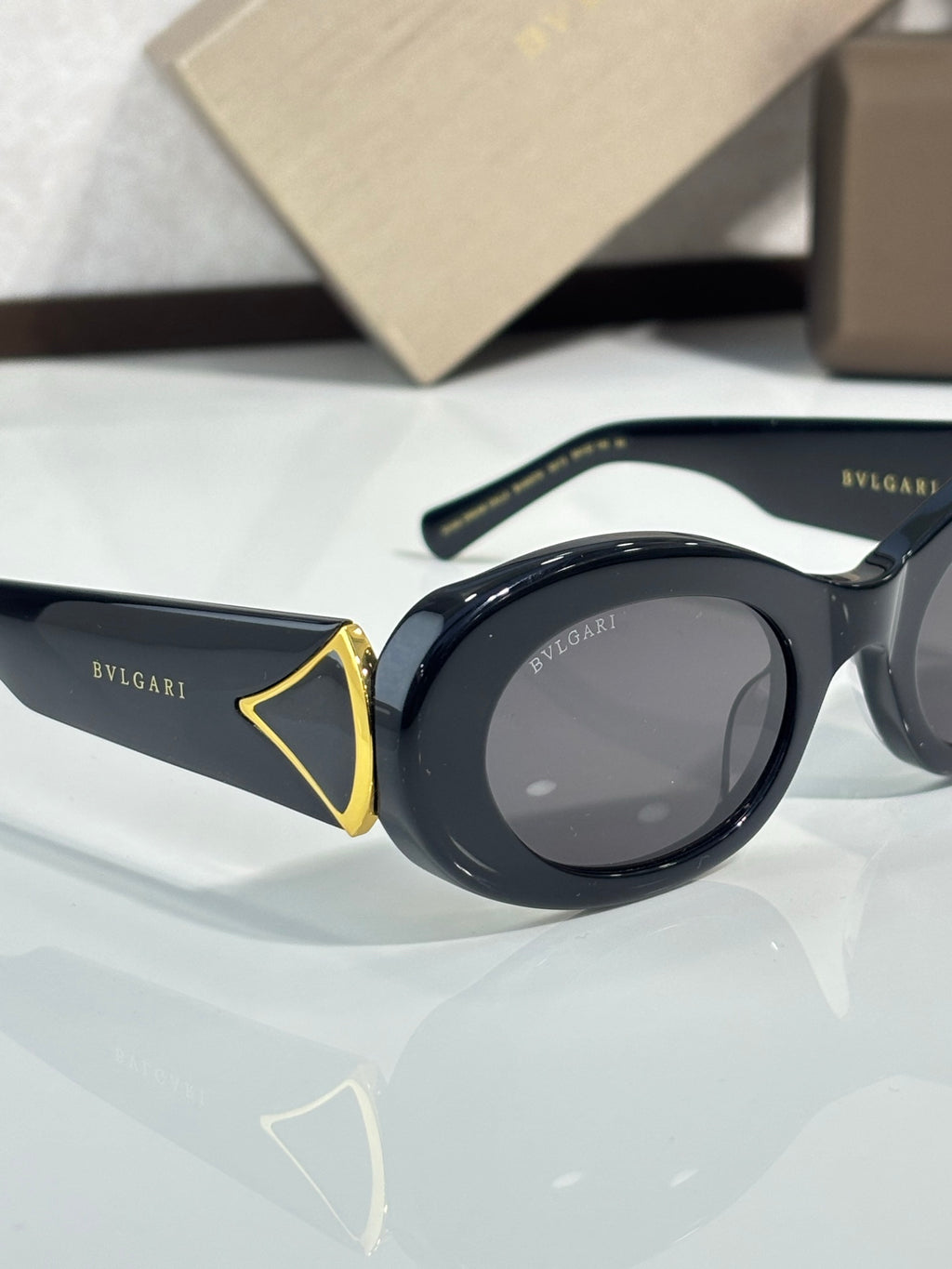 BVLGARI round-oval sunglasses with dark lenses and gold-trimmed hinge ornament
