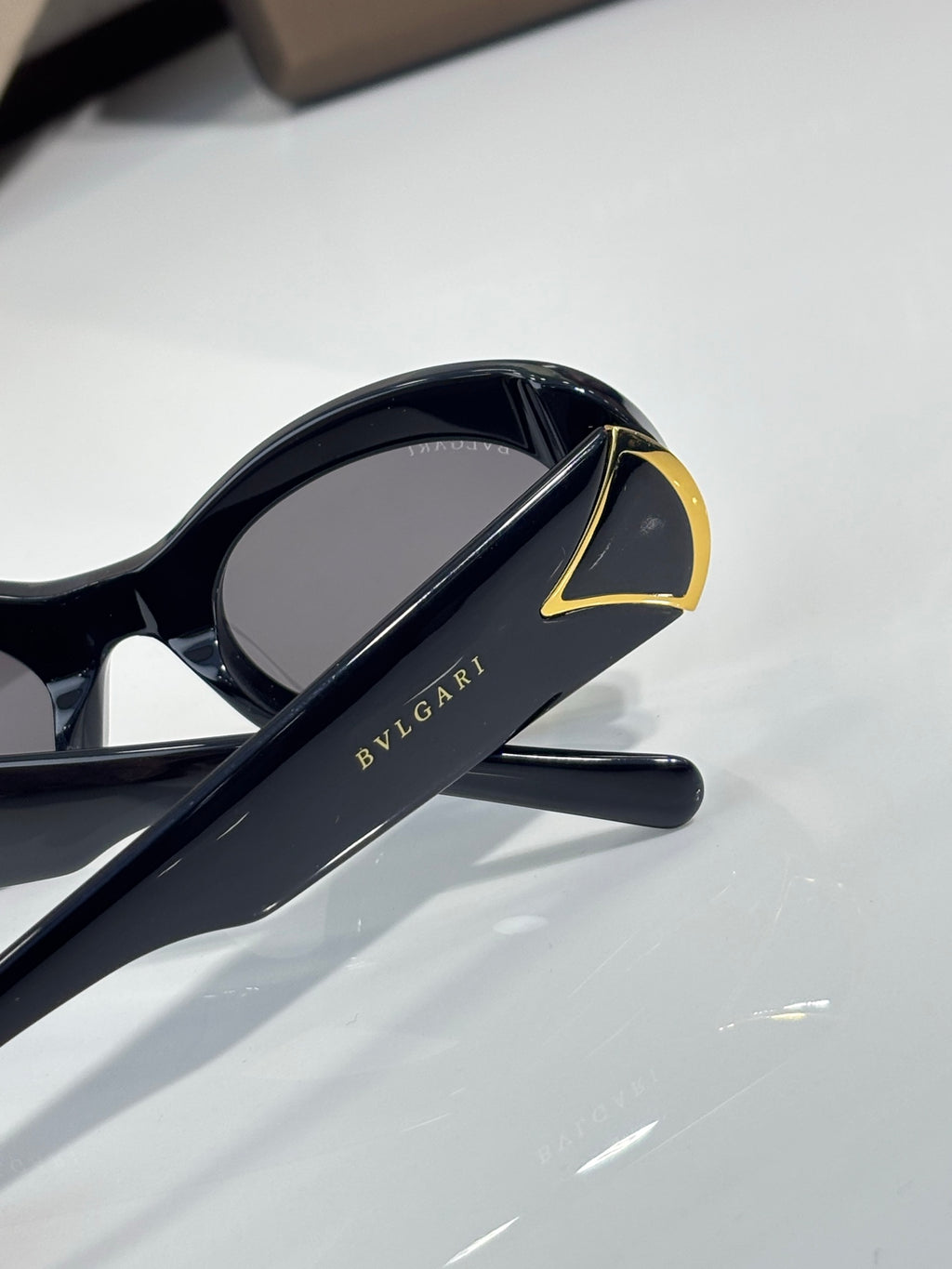 BVLGARI sunglasses with dark lenses, black frame and gold-trimmed temple end