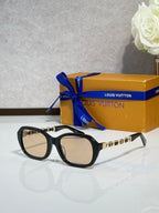 Sunglasses with black frame and tinted lenses, gold chain detail on arms