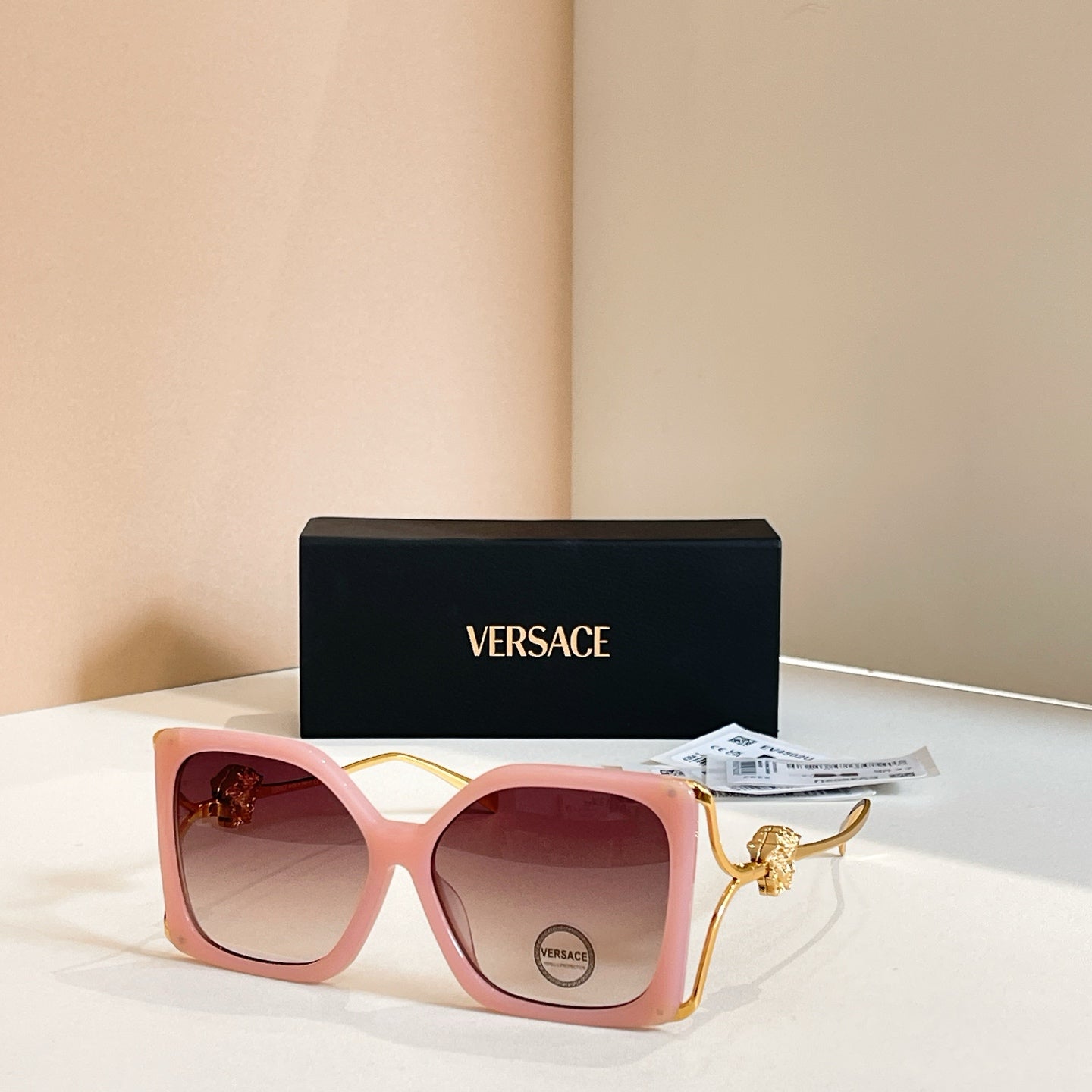 Versace sunglasses, pink square frames with gold Medusa temple detail, tinted lenses
