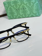 Gucci eyeglasses close-up with black frames, blue inner arms, and gold details