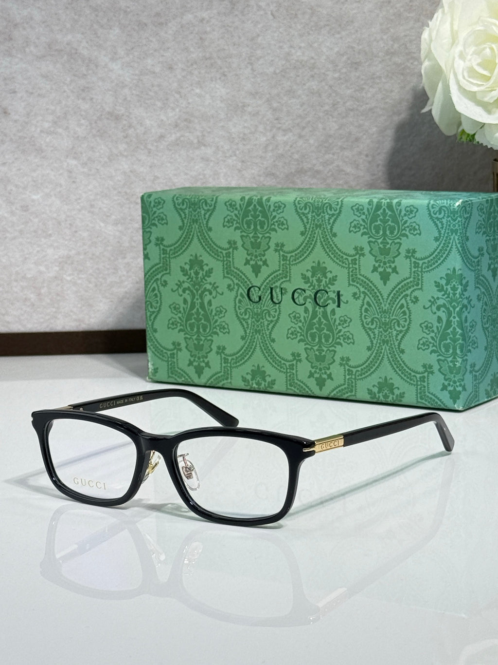 Gucci eyeglasses with black rectangular frames and clear lenses, gold detailing