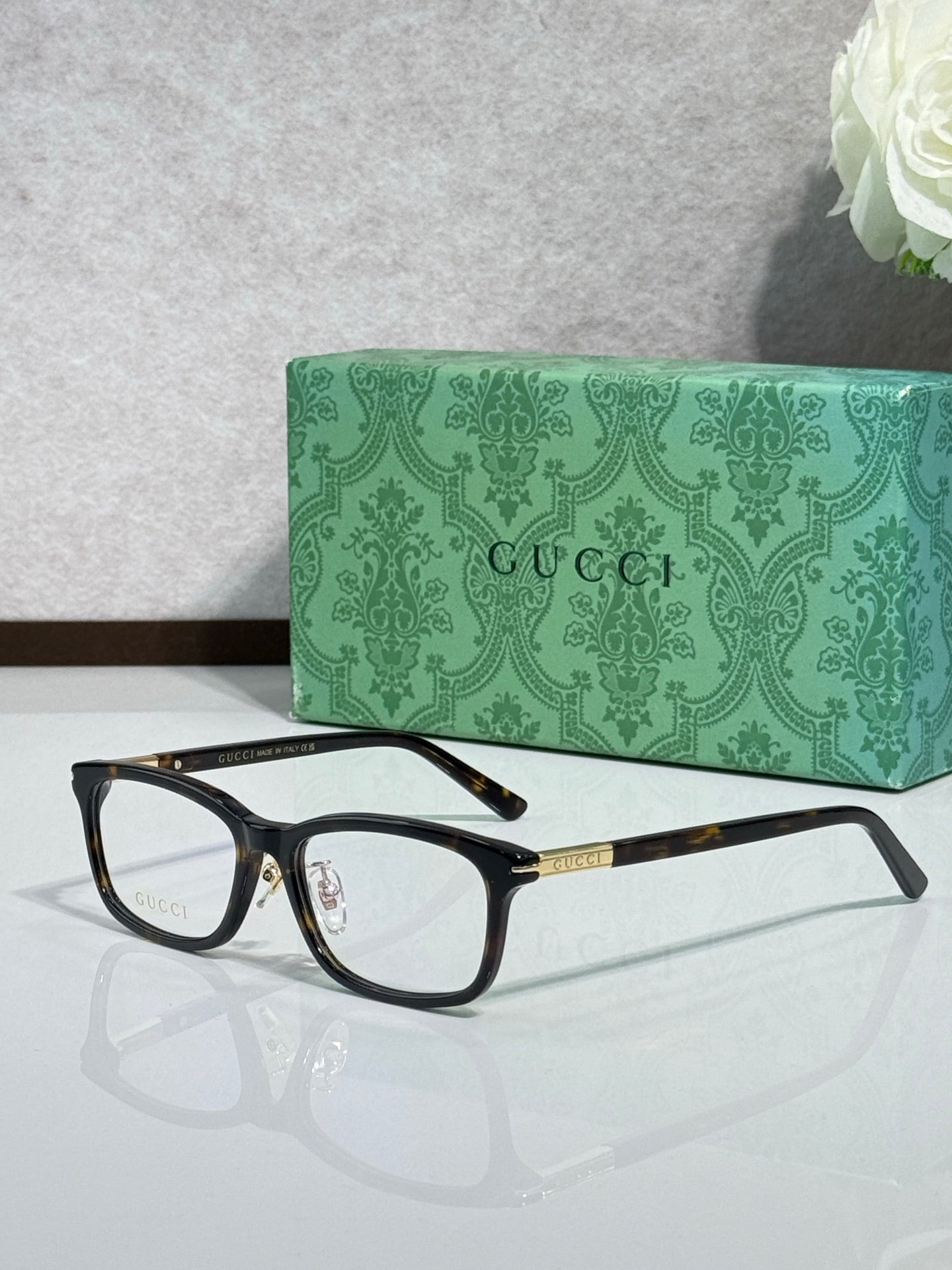 Gucci eyeglasses in side angle with black frames, clear lenses, and gold accents