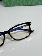 Gucci eyeglasses close-up of black frame and blue inner temple with gold hinge