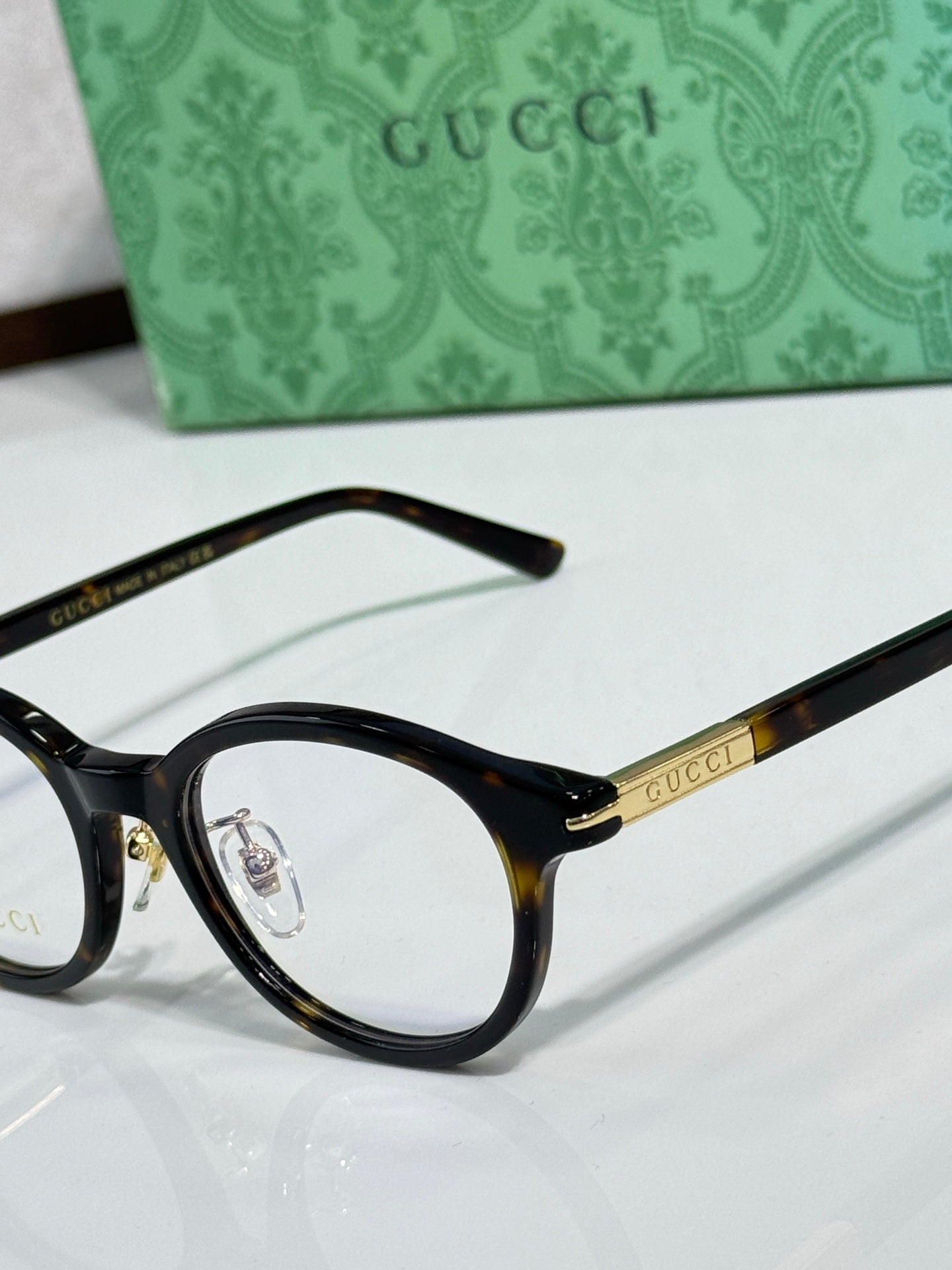 Gucci eyeglasses close-up of black round frame with gold temple logo