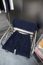 Navy patterned shorts with folded second pair on display stand