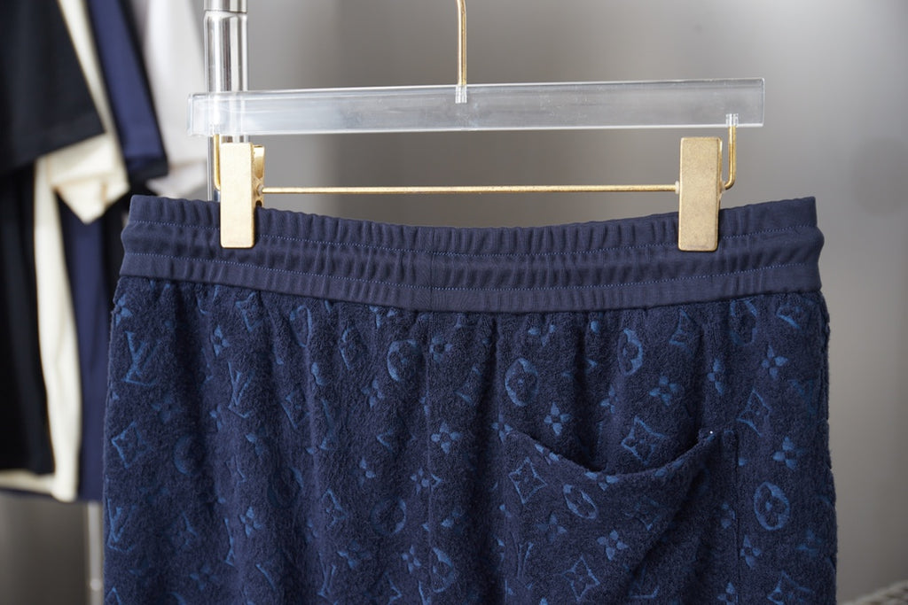 Navy patterned drawstring shorts on hanger, elastic waistband visible