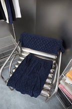 Navy patterned shorts and folded pair on metal display stand