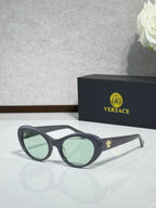 Versace black sunglasses with green-tinted lenses and clear temple tips