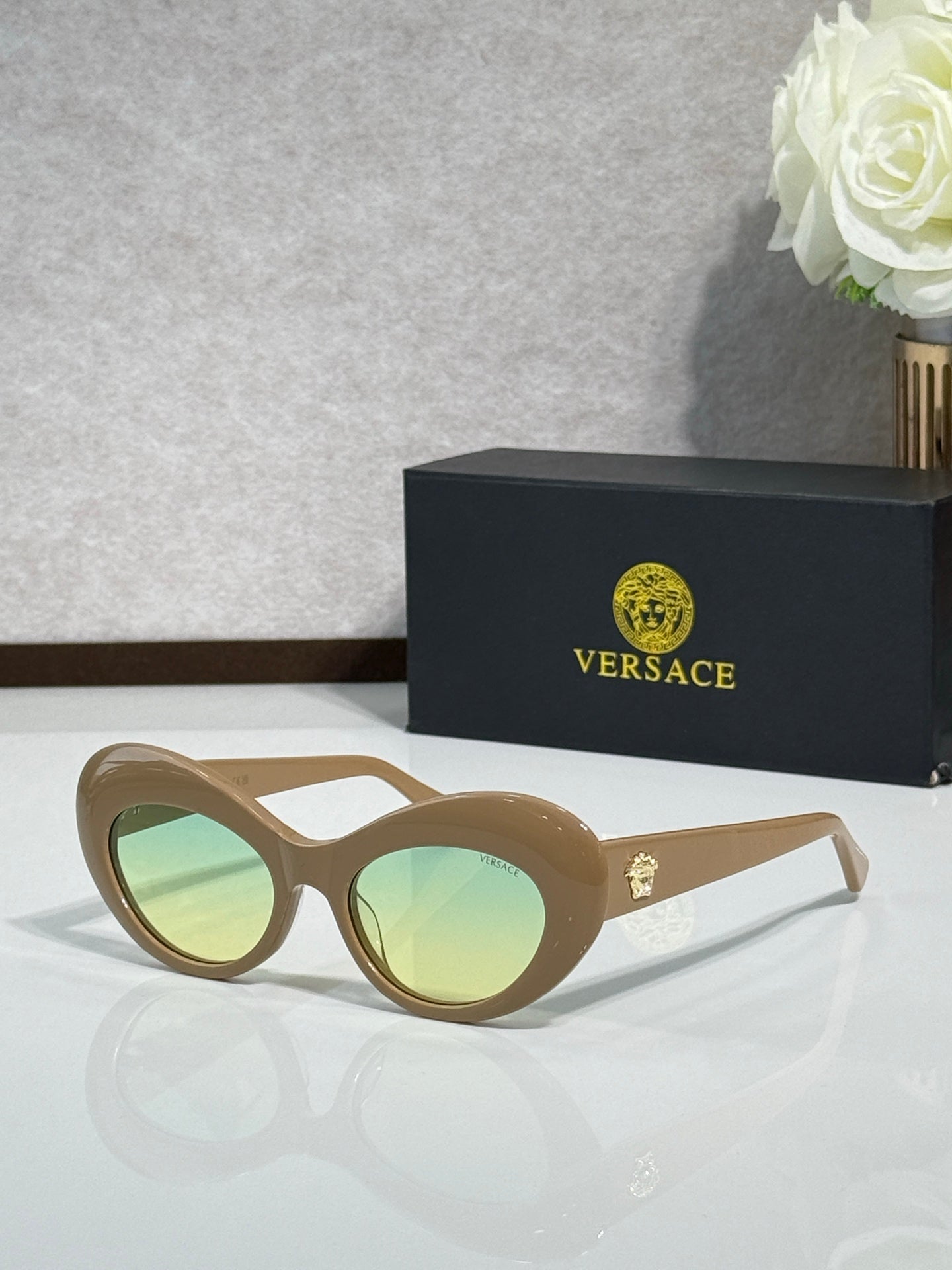 Versace sunglasses with light tan round frames and pale green lenses