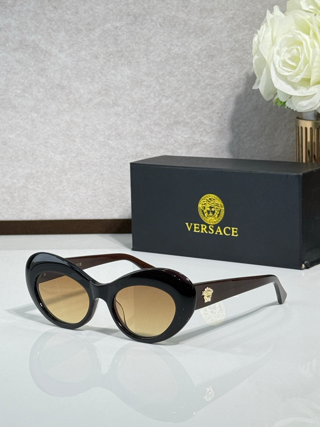 Versace sunglasses with black round frames and tan gradient lenses